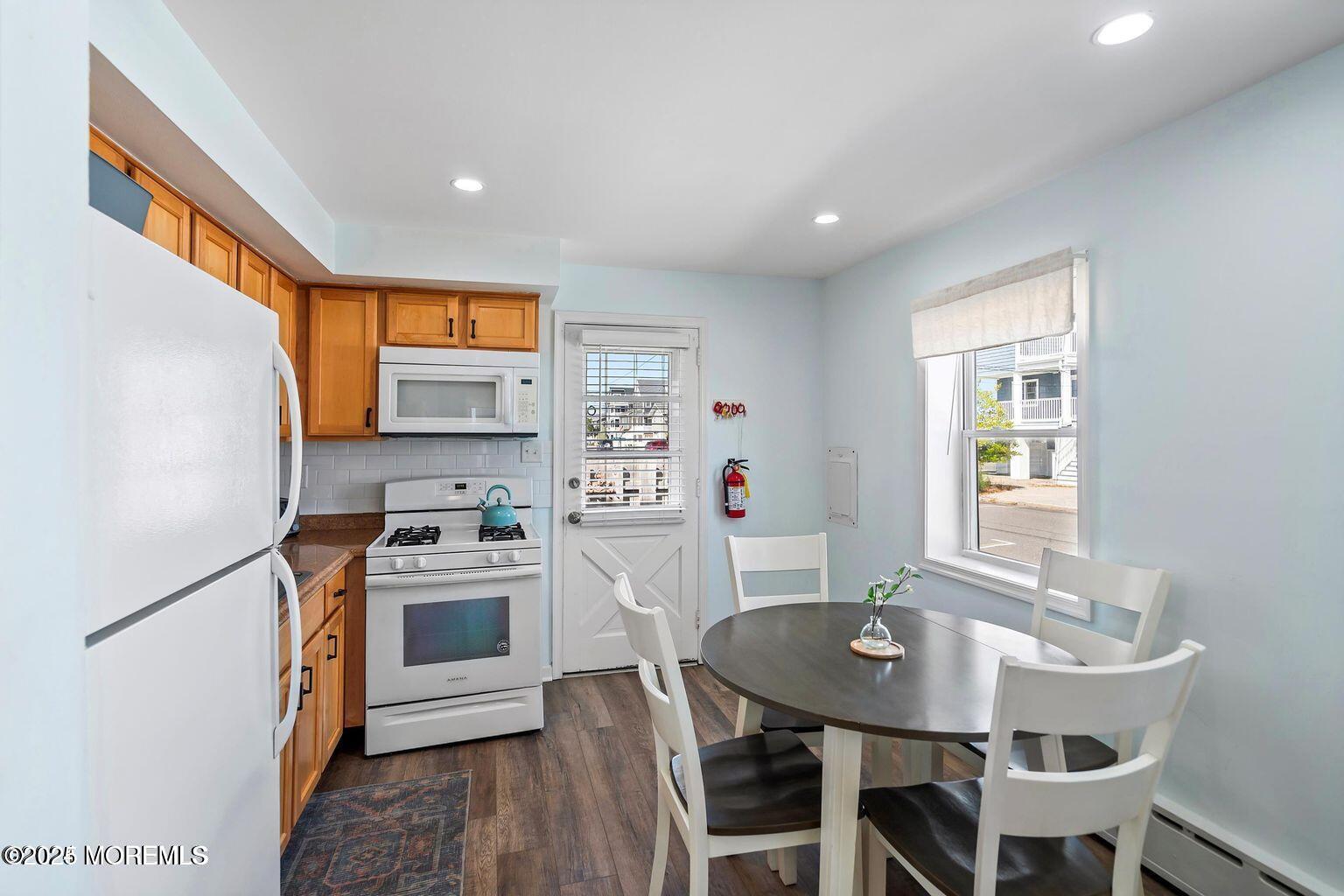 115-117 Coolidge Avenue Seaside Heights, NJ 08751 - Photo 14 of 25 a kitchen with stainless steel appliances granite countertop a stove a sink a microwave a refrigerator a dining table and chairs with wooden floor