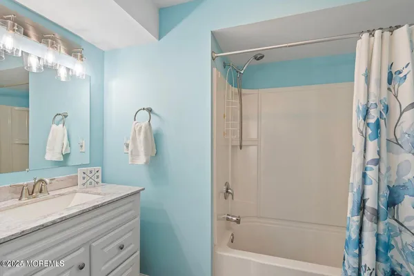 a bathroom with a granite countertop sink a mirror a shower and a bathtub