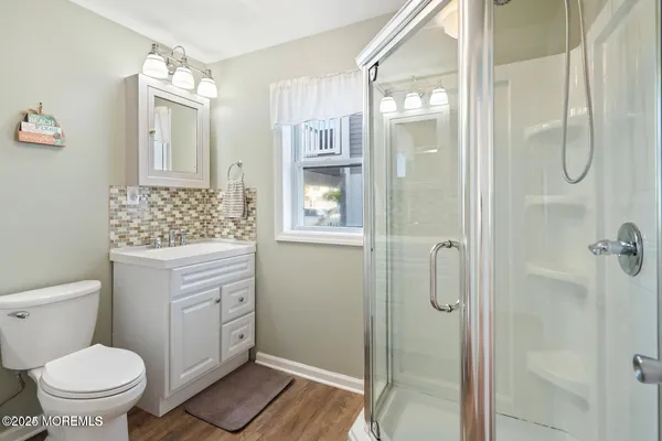 a bathroom with a granite countertop sink a toilet and shower