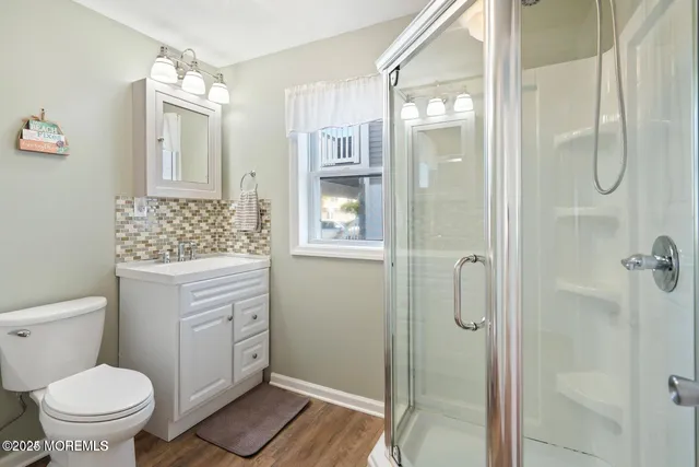 a bathroom with a granite countertop sink a toilet and shower