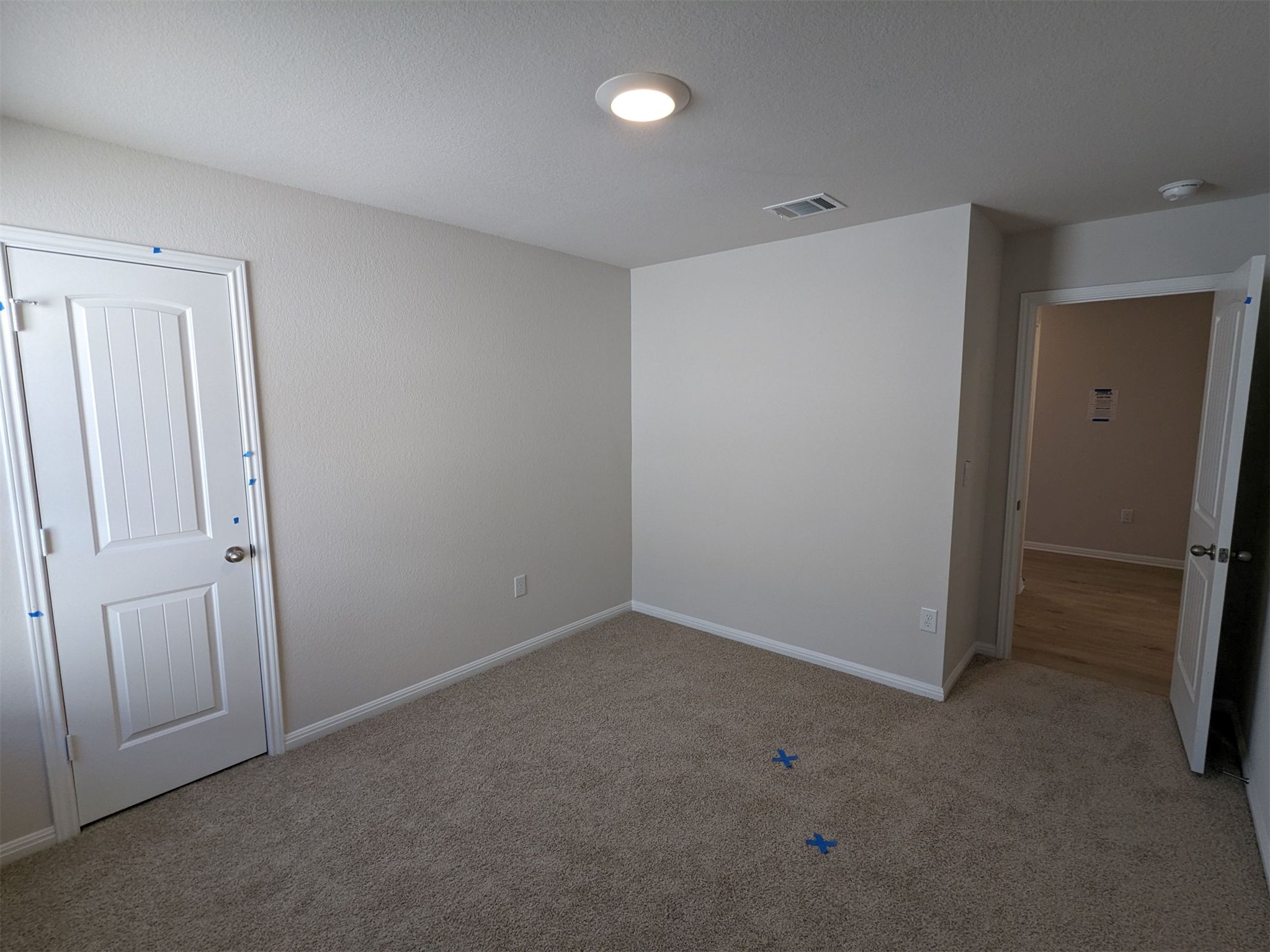 2412 Lightning View Leander, TX 78641 - Photo 18 of 24 A well-lit bedroom features plush carpeting and a clean, neutral palette.