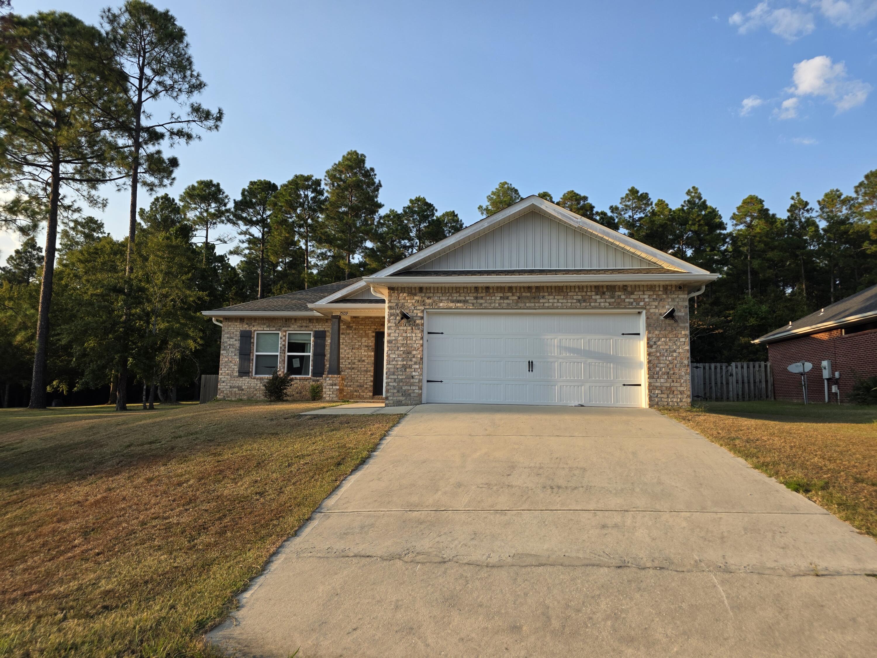 1509 Long Needle Court Baker, FL 32531 - Photo 2 of 14 a front view of a house with a yard and trees