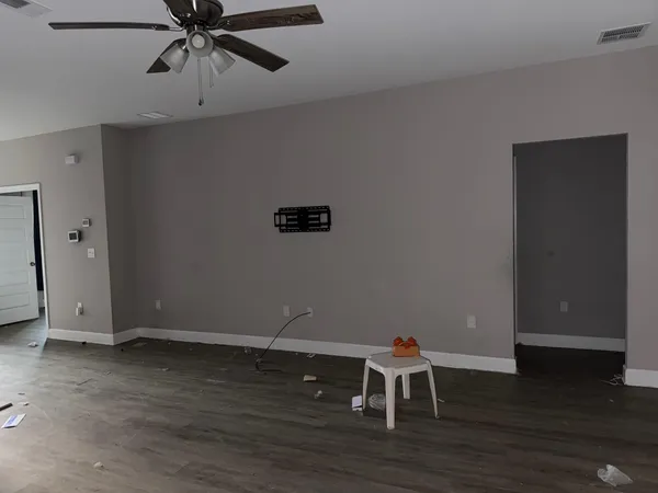 a view of a room with wooden floor and ceiling fan
