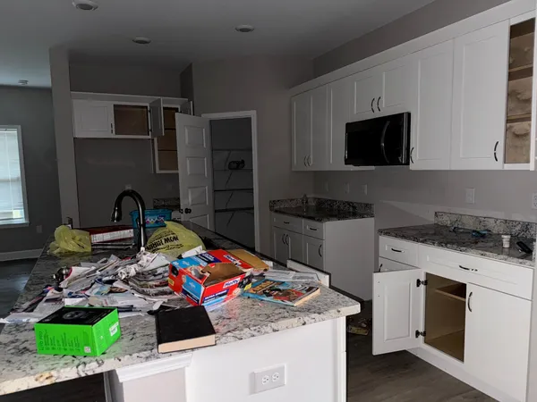 a utility room with stainless steel appliances kitchen island granite countertop a stove and a sink