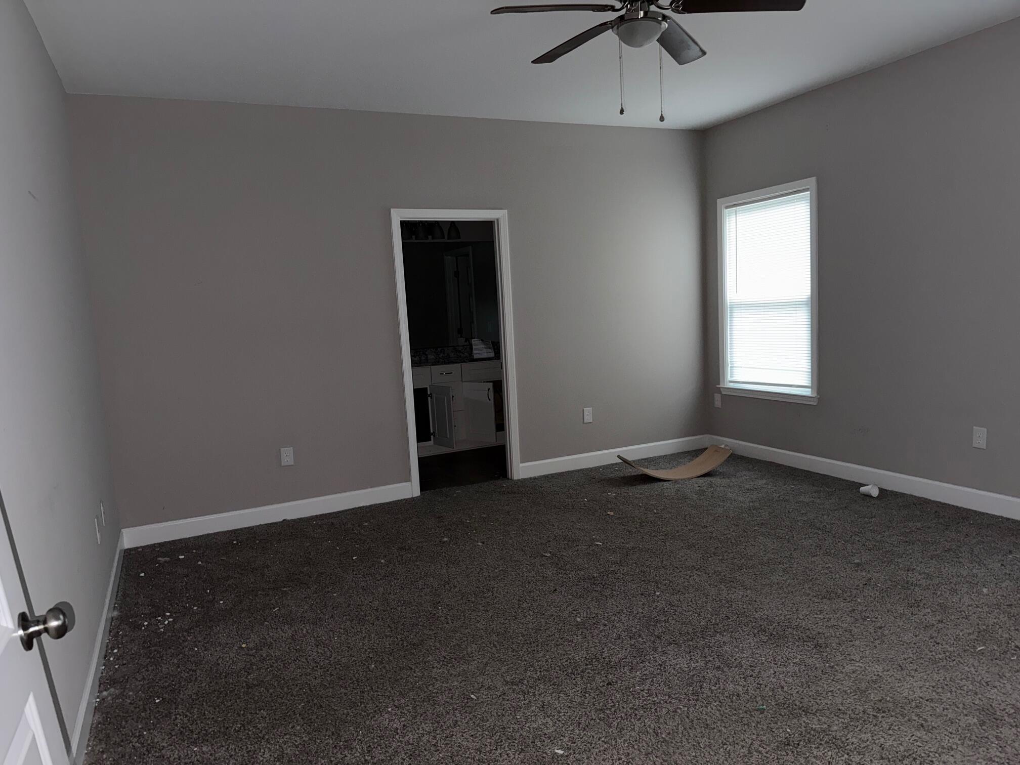 1509 Long Needle Court Baker, FL 32531 - Photo 9 of 14 an empty room with a chandelier fan and windows