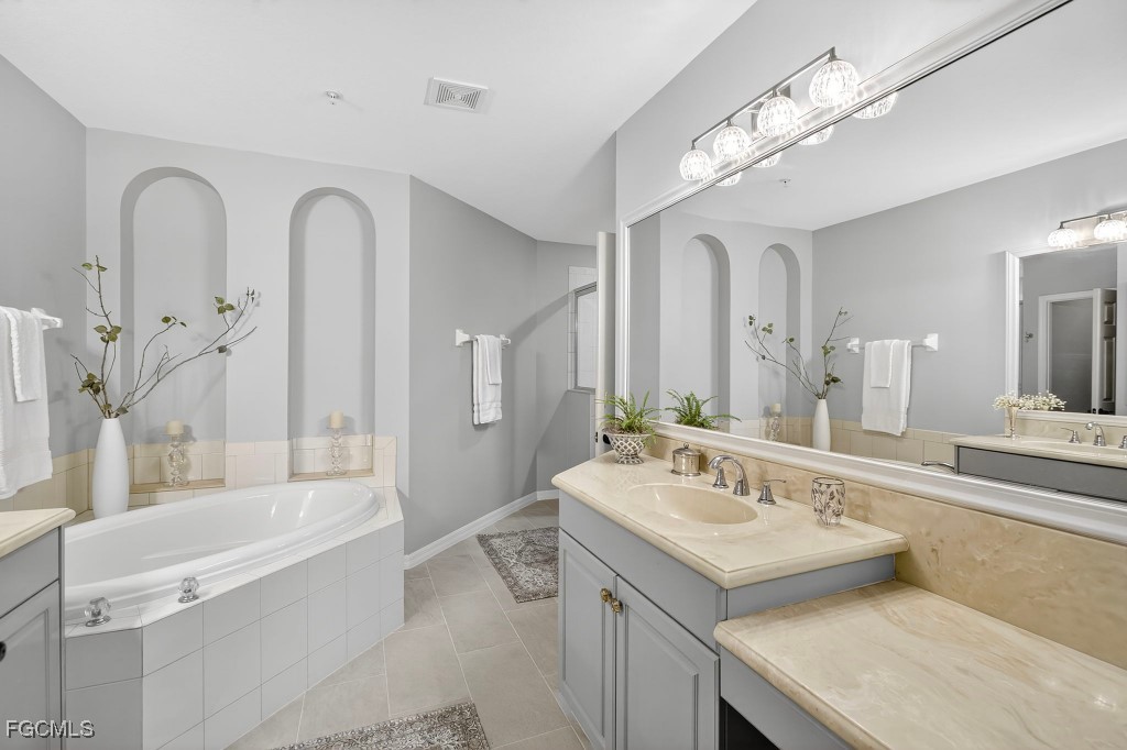 3610 Lansing Loop, Unit 102 Estero, FL 33928 - Photo 15 of 27 a bathroom with a tub a sink and a mirror