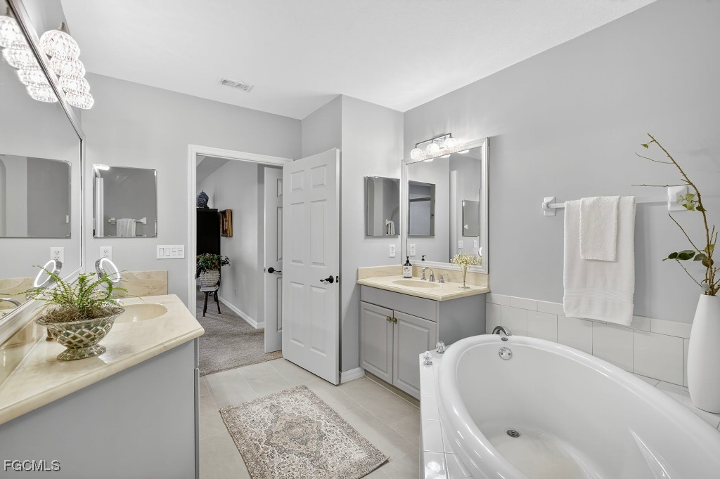 3610 Lansing Loop, Unit 102 Estero, FL 33928 - Photo 17 of 27 a spacious bathroom with a tub sink and mirror