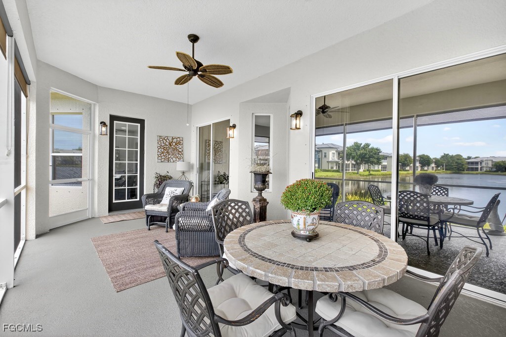 3610 Lansing Loop, Unit 102 Estero, FL 33928 - Photo 24 of 27 a living room with patio furniture and a floor to ceiling window