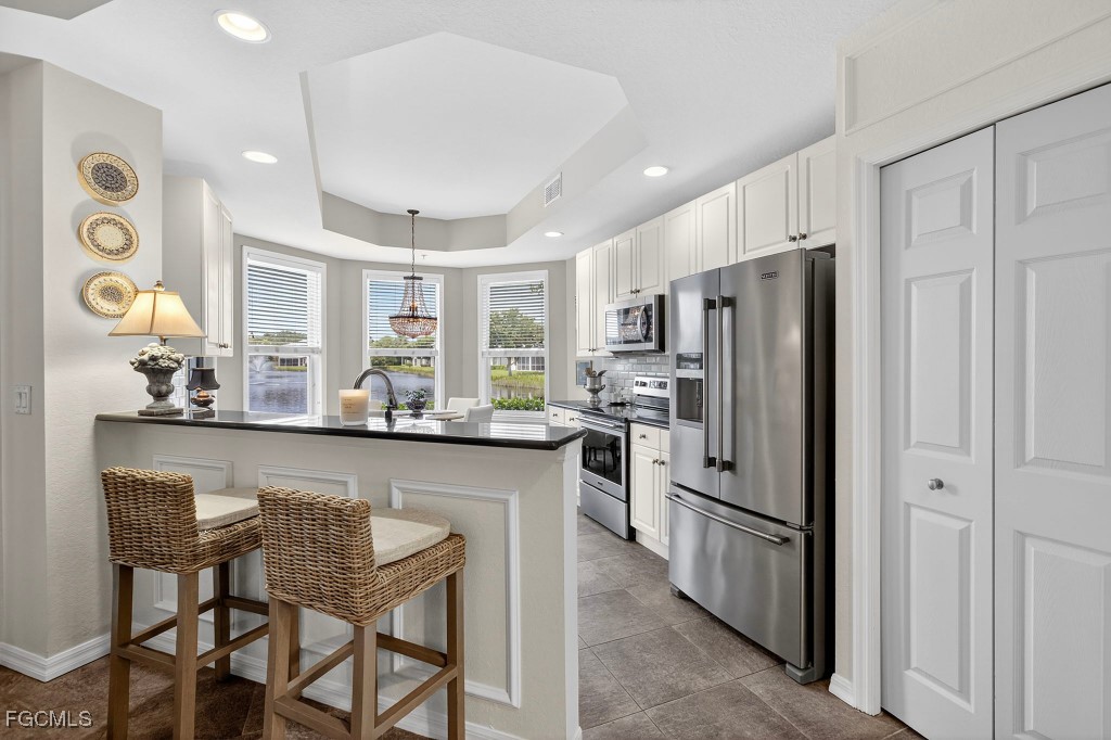 3610 Lansing Loop, Unit 102 Estero, FL 33928 - Photo 9 of 27 a kitchen with stainless steel appliances granite countertop a refrigerator and a stove top oven