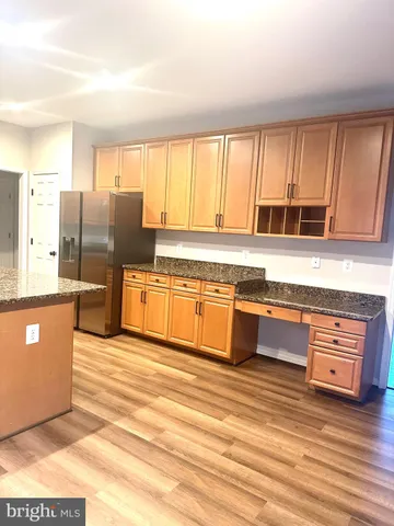 a large kitchen with stainless steel appliances granite countertop a stove a sink and a refrigerator