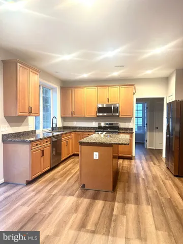 a kitchen with stainless steel appliances granite countertop a stove a sink dishwasher and a refrigerator