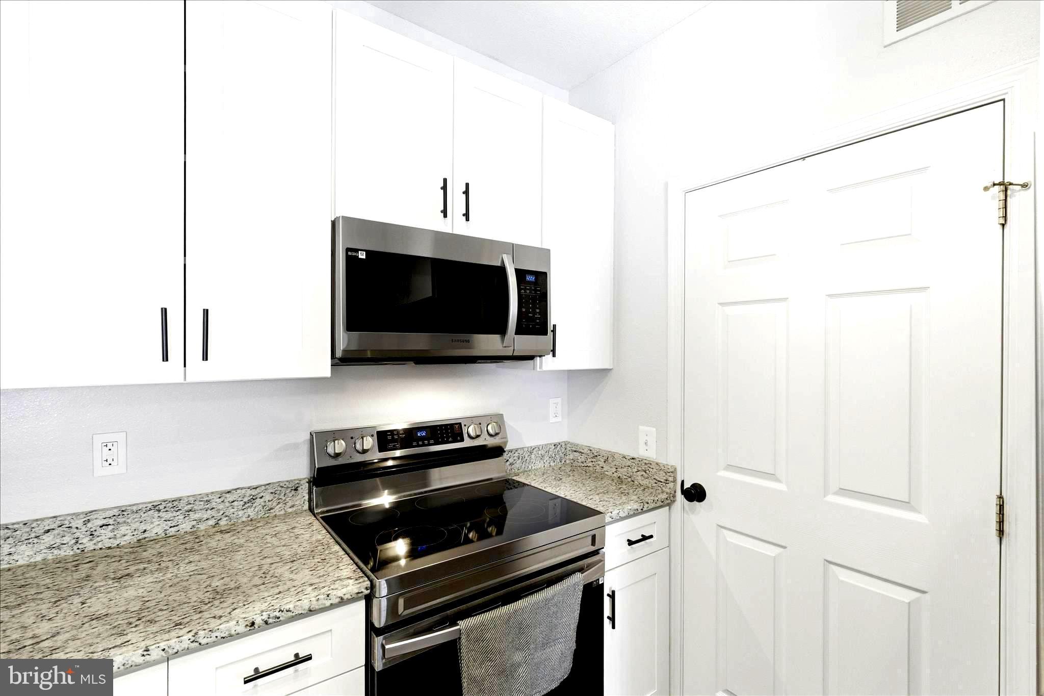 1601 Spring Gate Dr., Unit 1204 McLean, VA 22102 - Photo 12 of 52 a kitchen with a sink and a stove with wooden floor