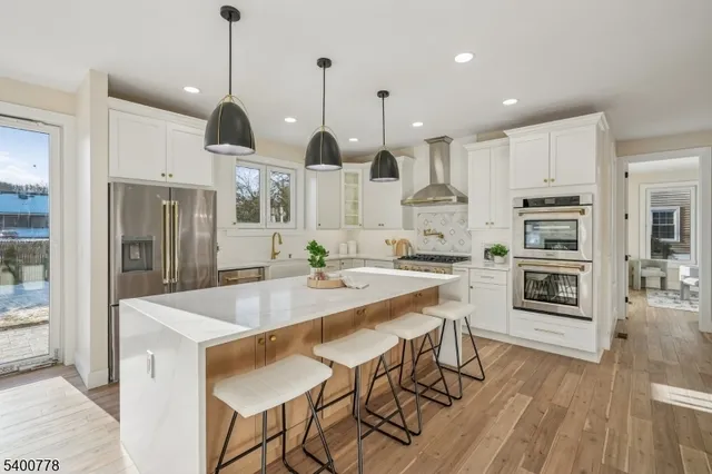 a kitchen with stainless steel appliances kitchen island granite countertop a kitchen island hardwood floor and a sink