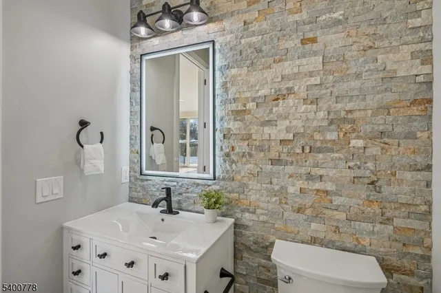 a bathroom with a sink a toilet and mirror