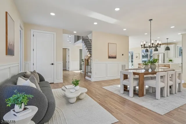 a living room with furniture kitchen view and a wooden floor