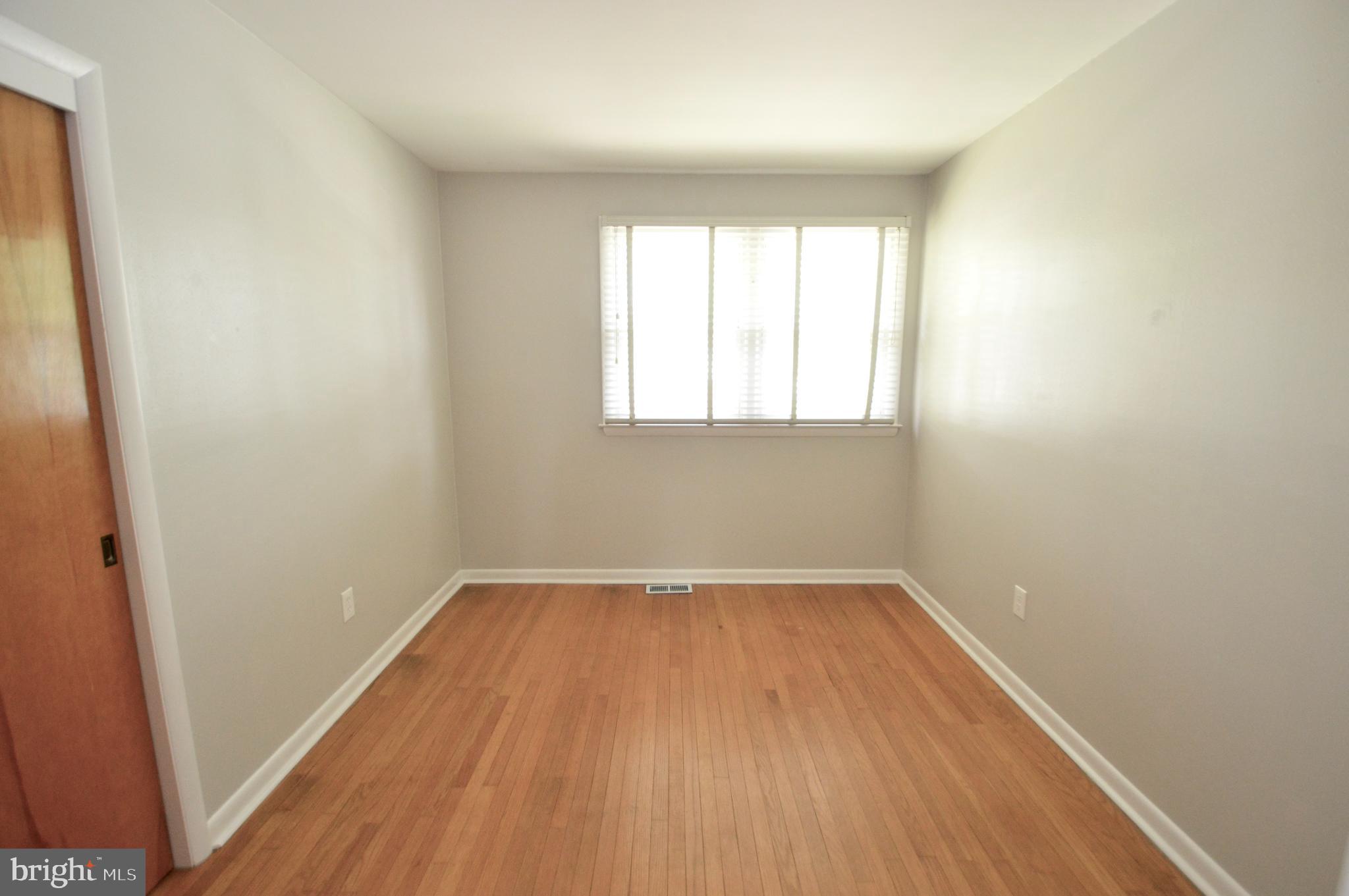 119 Ashbrook Road Cherry Hill, NJ 08034 - Photo 7 of 16 an empty room with wooden floor and windows