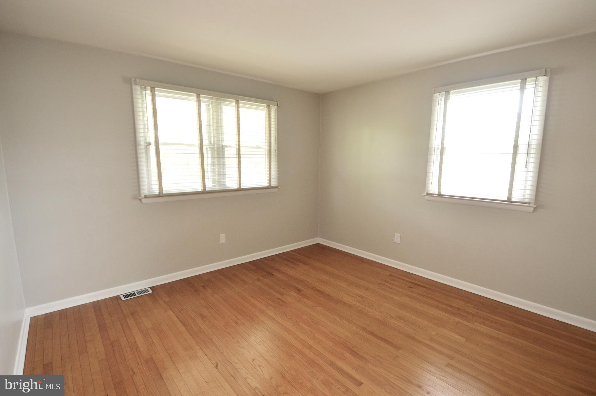 119 Ashbrook Road Cherry Hill, NJ 08034 - Photo 8 of 16 an empty room with wooden floor and windows