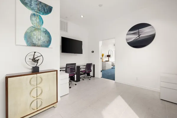 a view of a livingroom with workspace and a flat screen tv