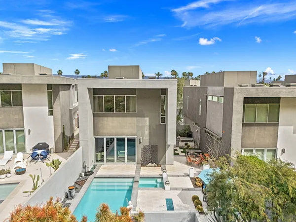 a view of a patio with couches table and chairs under an umbrella with wooden floor