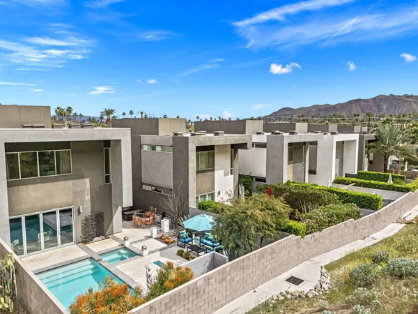 a view of a patio with couches table and chairs with wooden floor and fence