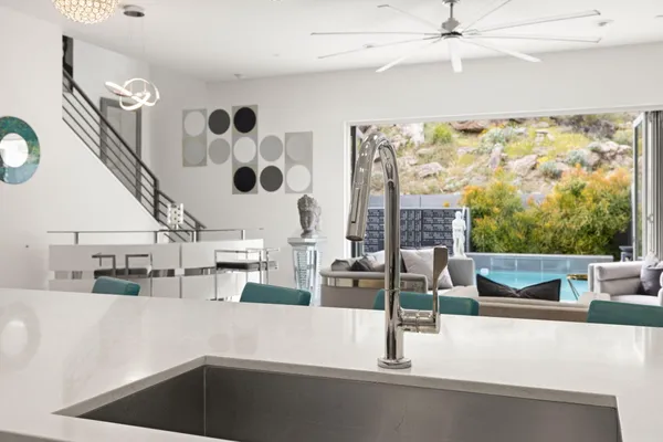 a kitchen with stainless steel appliances kitchen island a table chairs in it and wooden floors