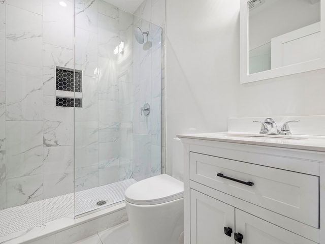 a bathroom with a sink a toilet and shower