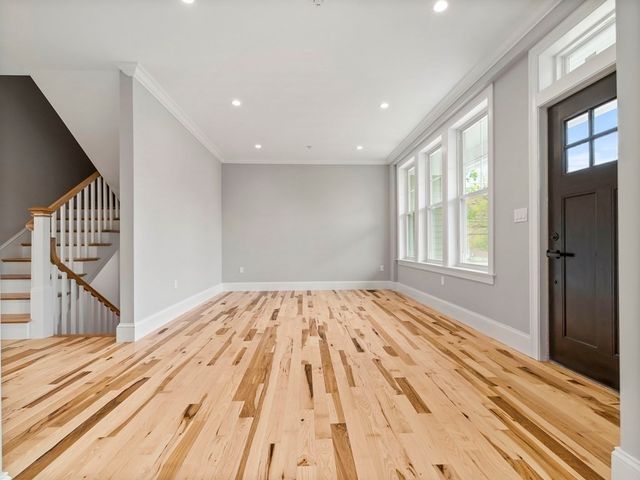a view of empty room with wooden floor and windows