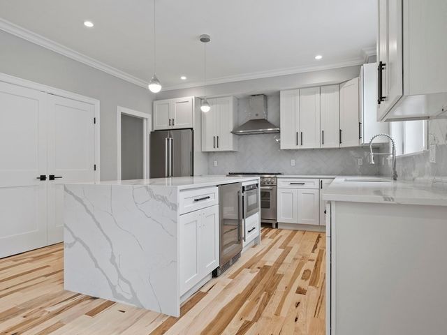 a kitchen with white cabinets appliances and sink
