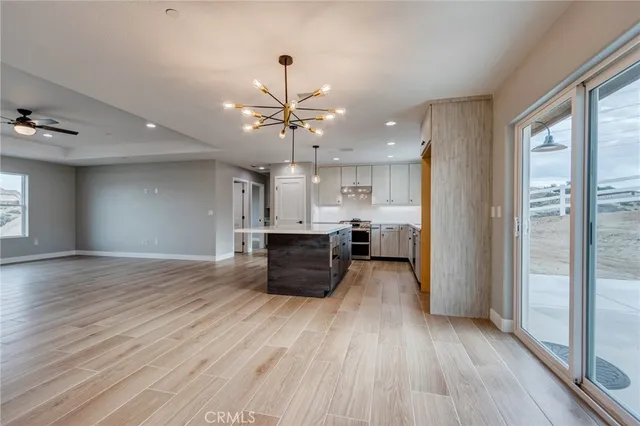 a kitchen with stainless steel appliances kitchen island wooden floors and view living room