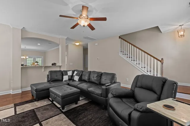 a living room with furniture and a ceiling fan