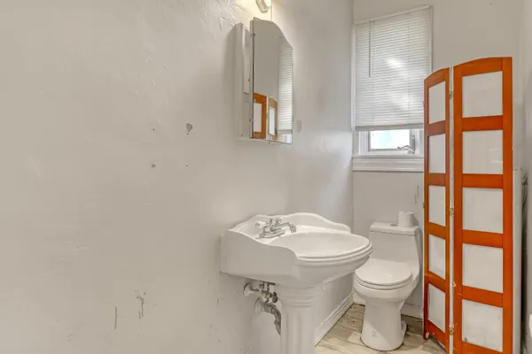 a bathroom with a toilet a sink and mirror
