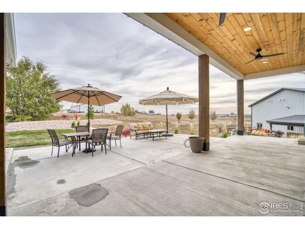 a view of a patio with a table and chairs under an umbrella