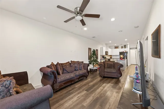 a living room with furniture kitchen view and a flat screen tv