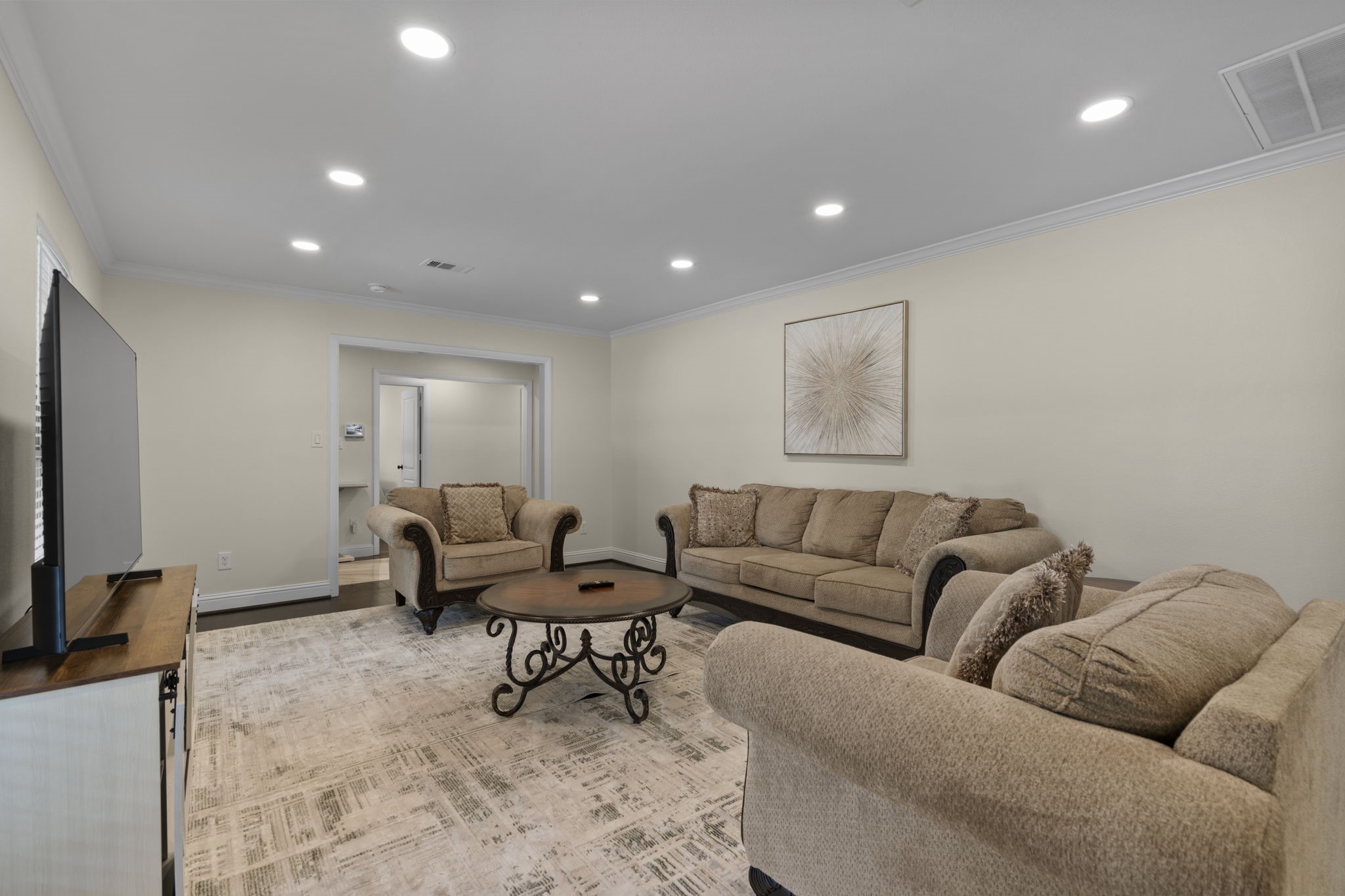 2402 Chimney Rock Road Houston, TX 77057 - Photo 10 of 36 The bright interior offers a seamless open layout with refined crown molding, LED recessed lighting, and rich dark floors throughout. Spacious living areas and oversized windows create an inviting, airy feel.