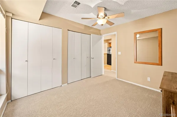 a view of an empty room with a chandelier fan