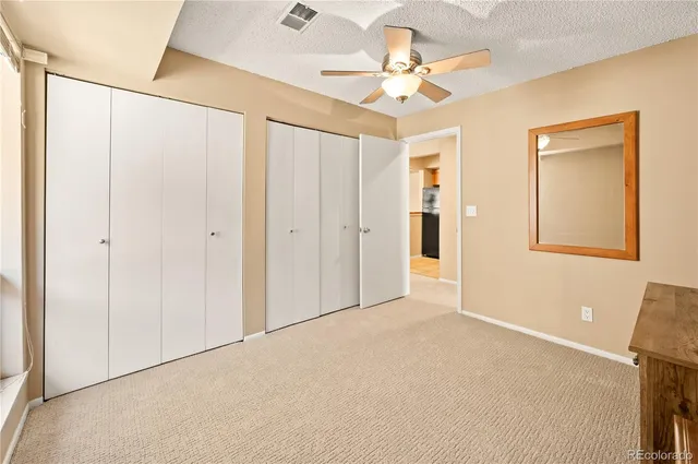 a view of an empty room with a chandelier fan