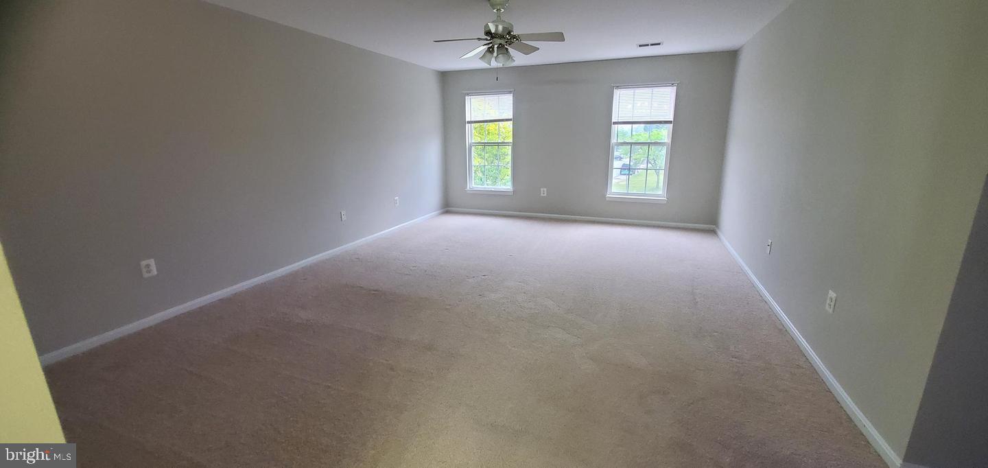 12969 Queen Chapel Road Woodbridge, VA 22193 - Photo 8 of 15 an empty room with windows and ceiling fan