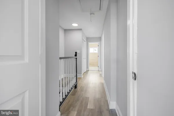 a view of a hallway with wooden floor and entryway