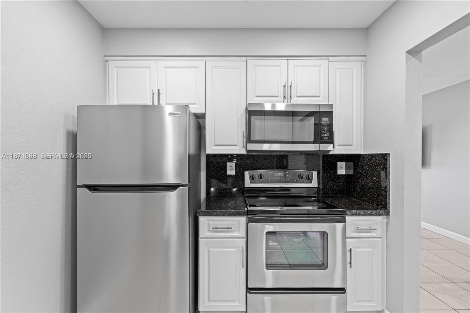 11740 Southwest 182nd Terrace Miami, FL 33177 - Photo 14 of 44 a white refrigerator freezer and a stove sitting inside of a kitchen