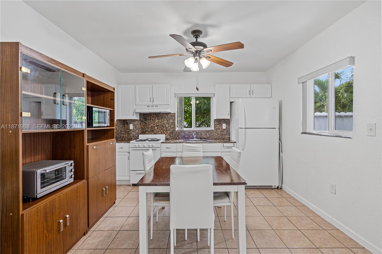 11740 Southwest 182nd Terrace Miami, FL 33177 - Photo 30 of 44 a kitchen with stainless steel appliances granite countertop a refrigerator a stove a microwave oven a sink with island and chairs