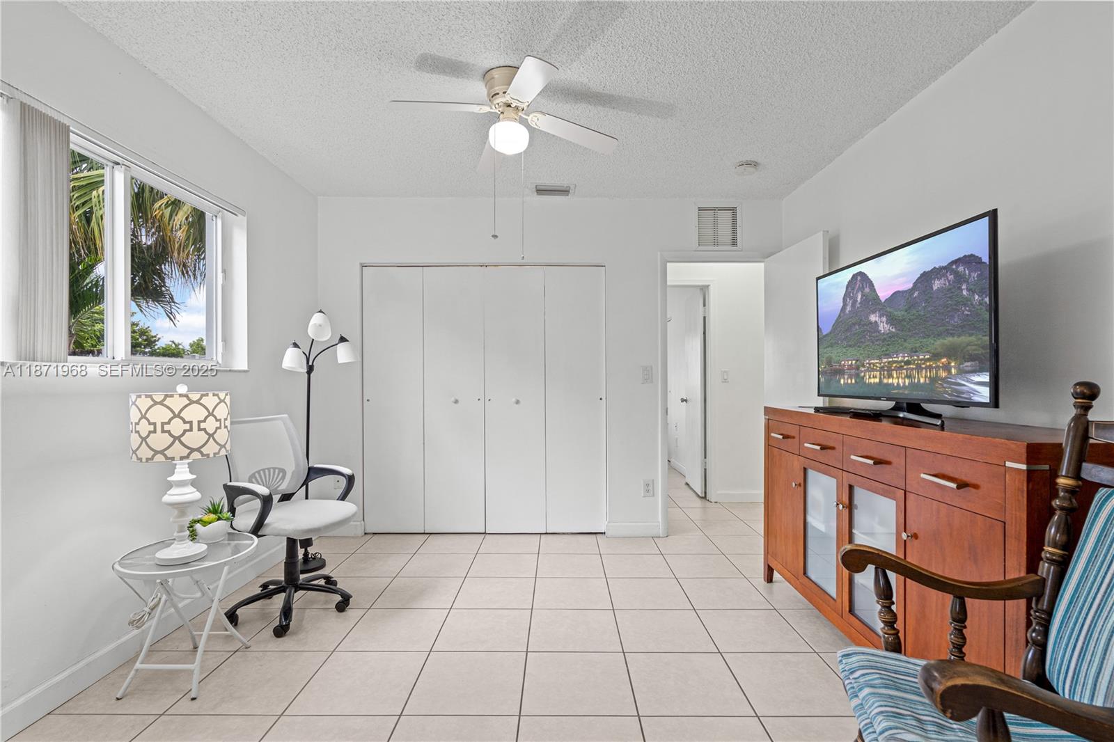 11740 Southwest 182nd Terrace Miami, FL 33177 - Photo 32 of 44 a living room with furniture a flat screen tv and a window