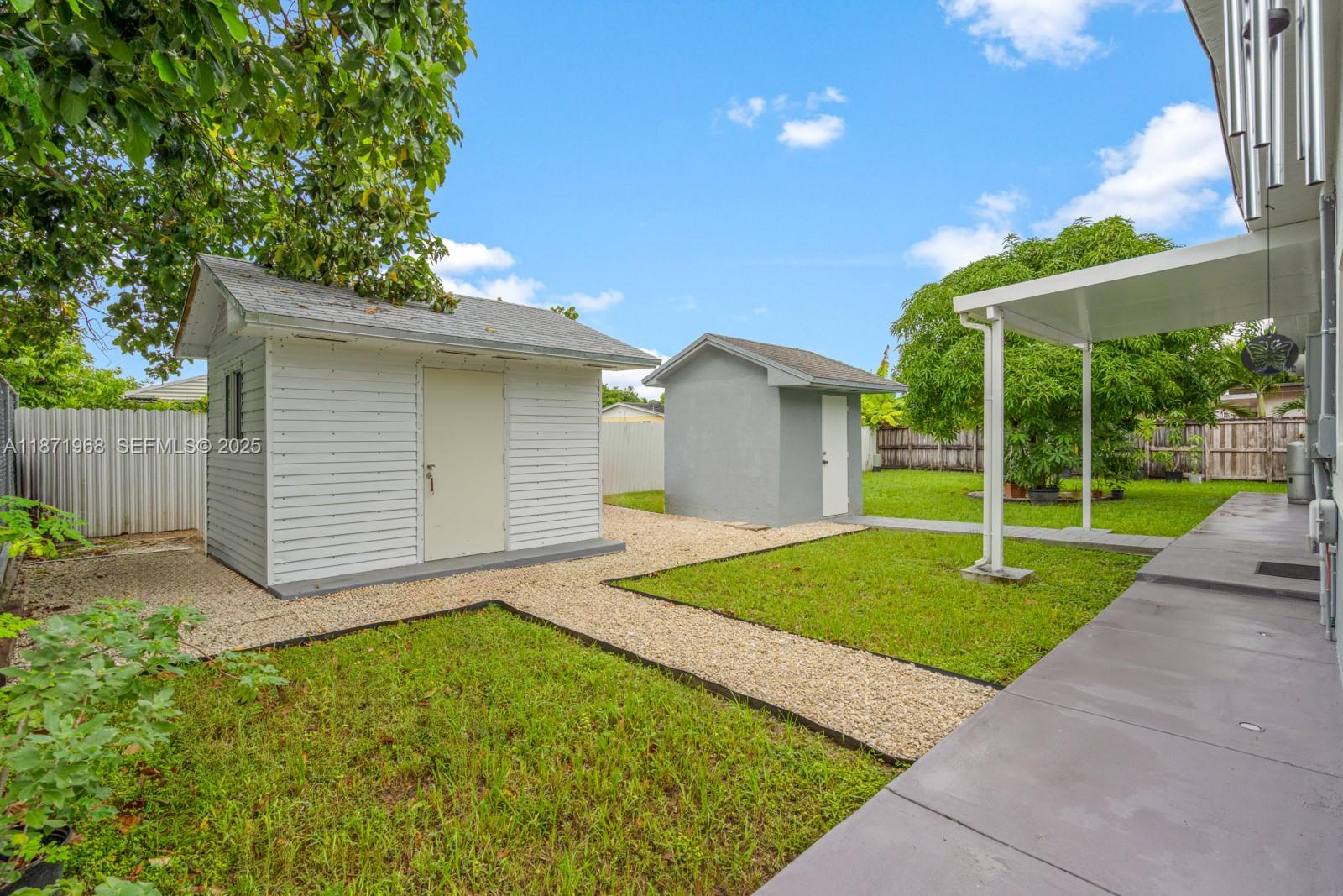 11740 Southwest 182nd Terrace Miami, FL 33177 - Photo 39 of 44 a view of a backyard with a barbeque grill and wooden fence