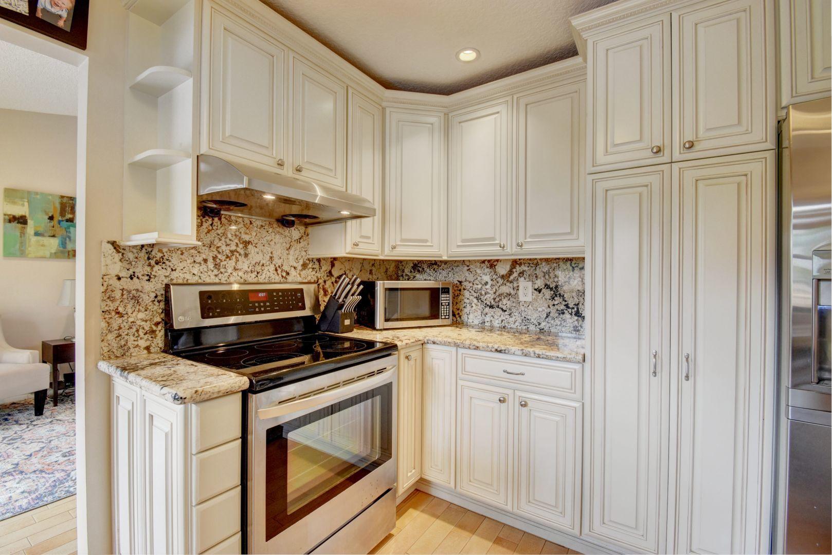 9525 Denver Court Boca Raton, FL 33434 - Photo 11 of 26 a kitchen with white cabinets and appliances