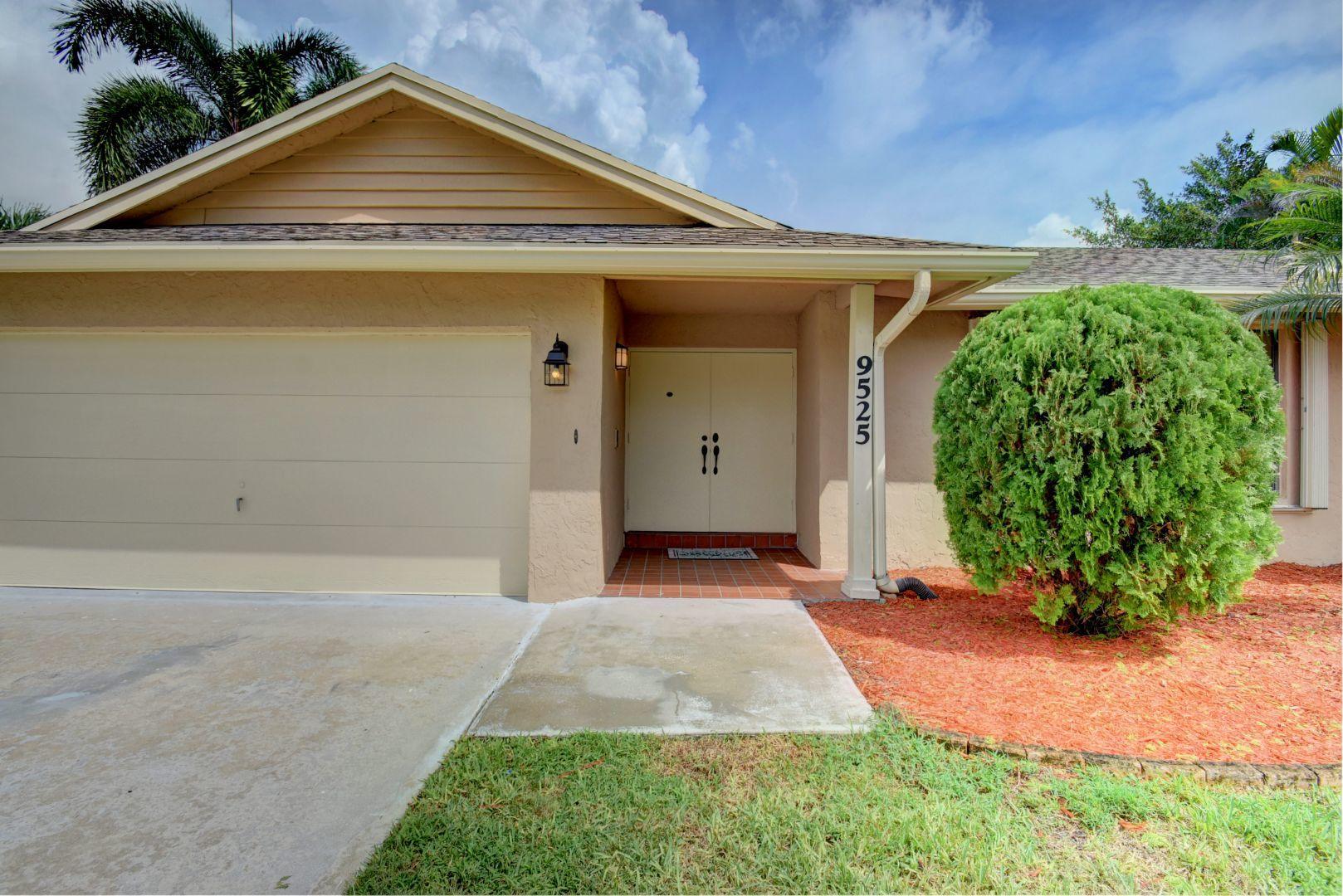 9525 Denver Court Boca Raton, FL 33434 - Photo 2 of 26 a view of a house with a small yard and potted plants