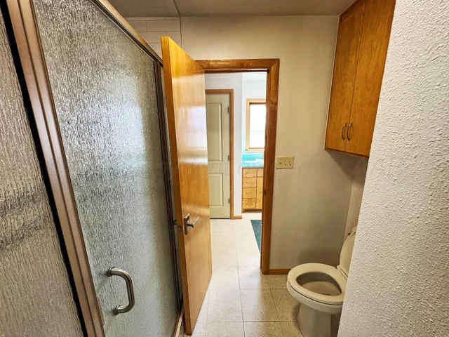 a bathroom with a granite countertop toilet and a shower