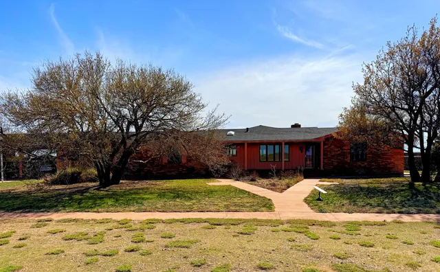 a view of swimming pool with outdoor seating and house in the background