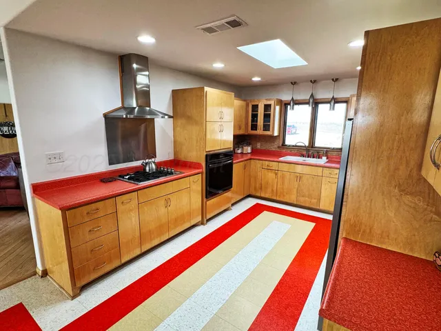 a kitchen with stainless steel appliances granite countertop a refrigerator and a stove