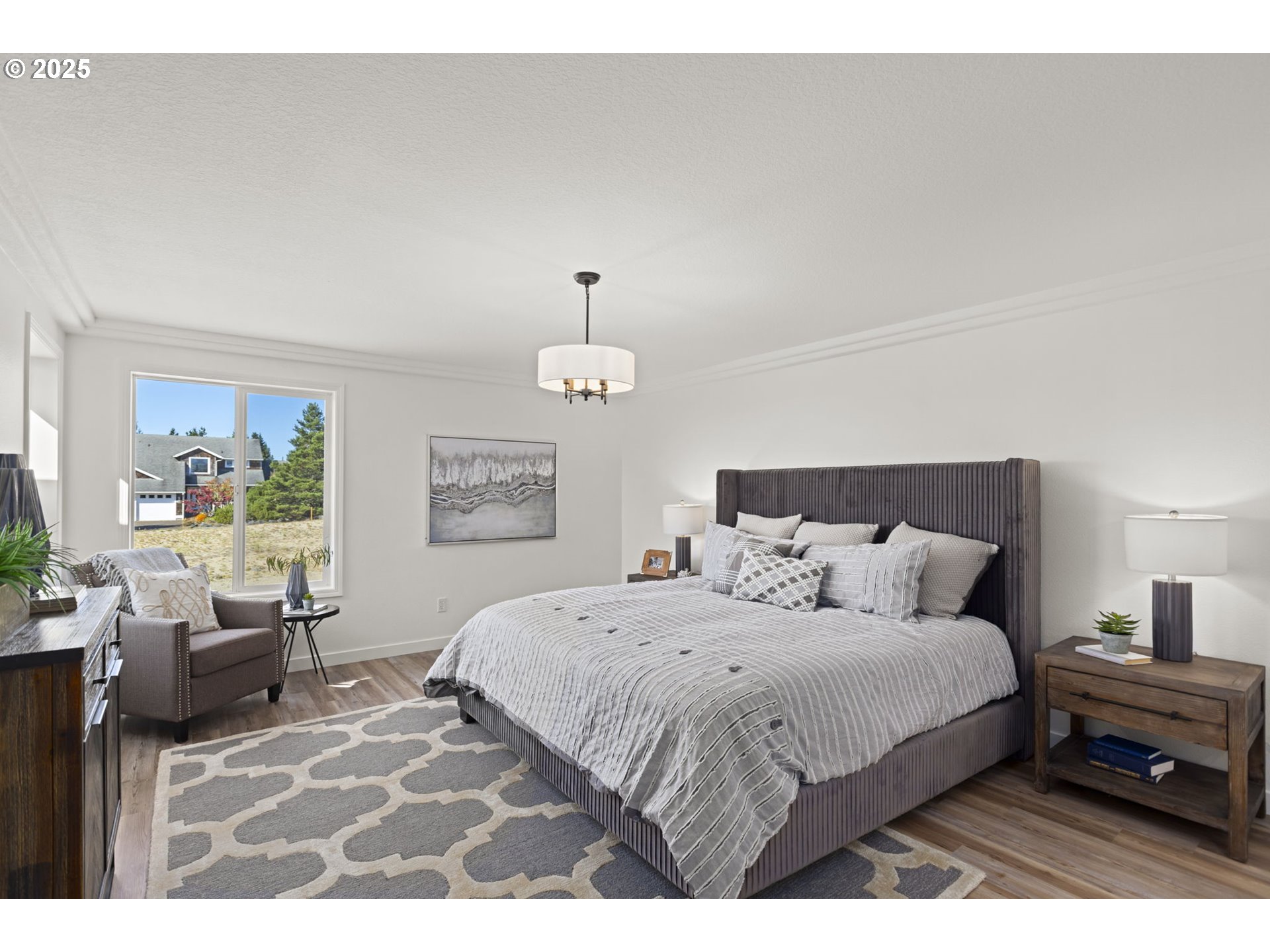 9980 Pine Ridge Drive Nehalem, OR 97131 - Photo 12 of 27 a bedroom with a bed and a chandelier