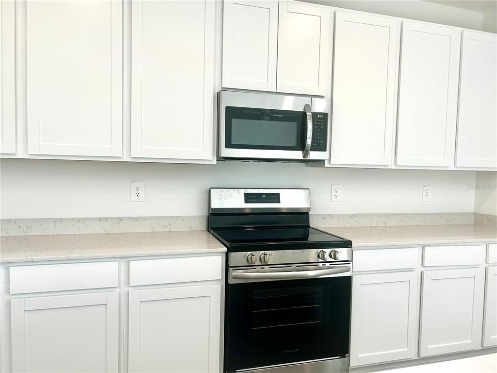 1103 Northwest 44th Court Road Ocala, FL 34482 - Photo 13 of 36 a kitchen with a stove and a microwave