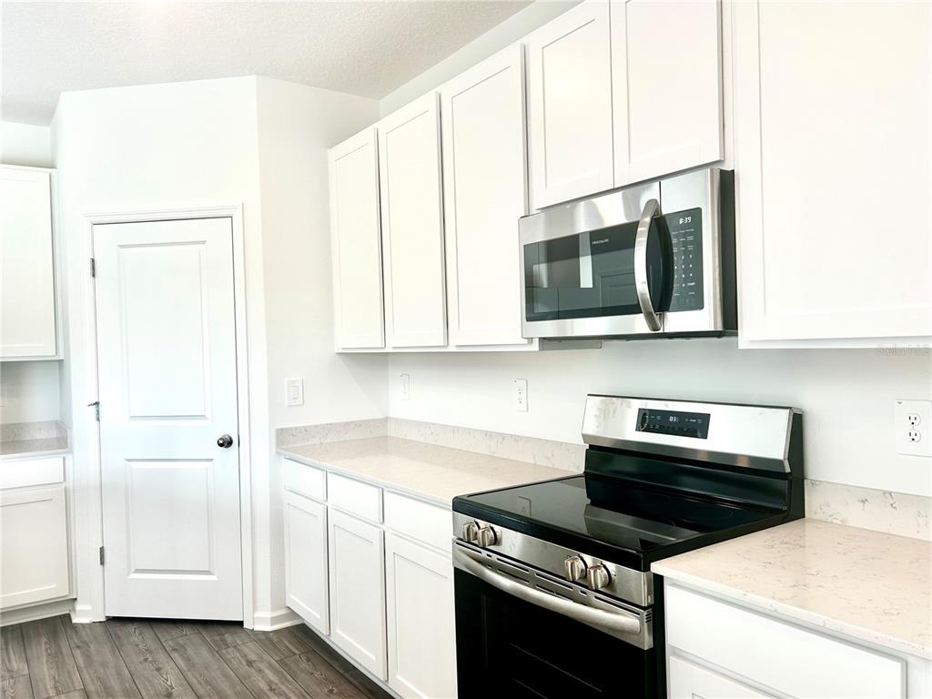 1103 Northwest 44th Court Road Ocala, FL 34482 - Photo 14 of 36 a kitchen with stainless steel appliances a stove microwave and cabinets